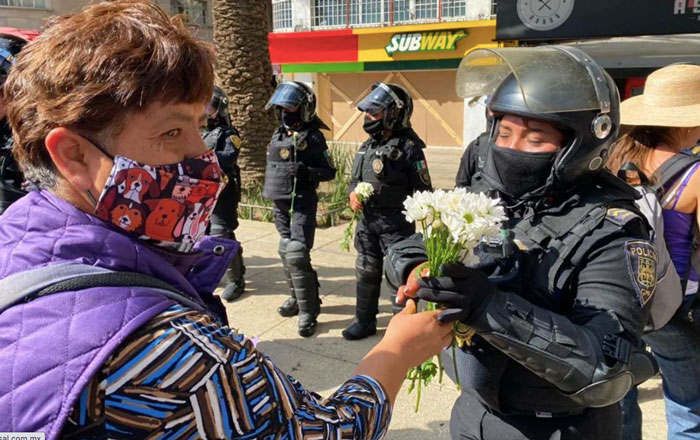 Mujeres policías reciben flores de manifestantes durante marcha 2 flore