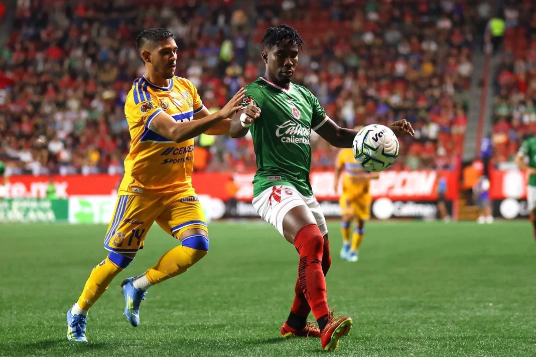 debut-de-tigres-apertura-2026 Jugadores disputando el balón en el debut de Tigres en el Estadio Caliente ante Xolos