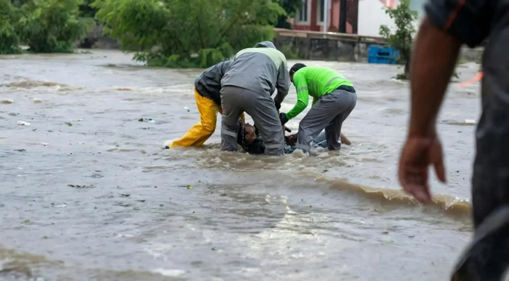 Recolectores de Red Ambiental rescatan a automovilista varado por la lluvia en Monterrey 2 Personal de Red Ambiental auxiliando a un automovilista atrapado por la corriente en Monterrey.